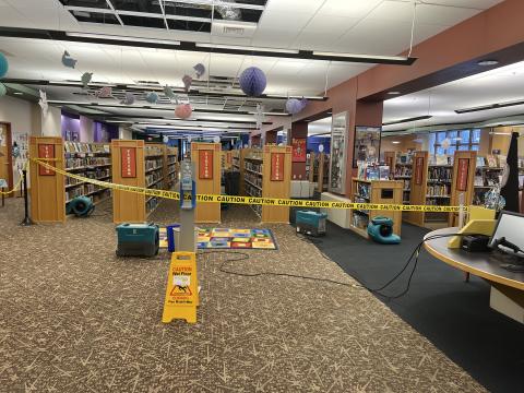 Caution tape in front of Youth Services shelving, blocking off most of department