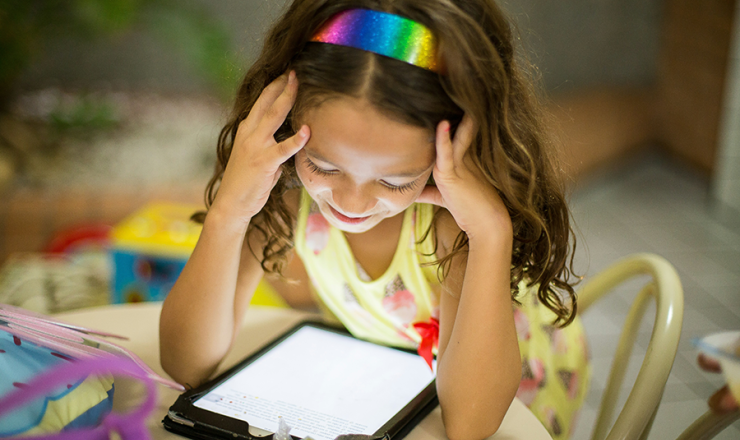 Girl smiling and looking down at a tablet