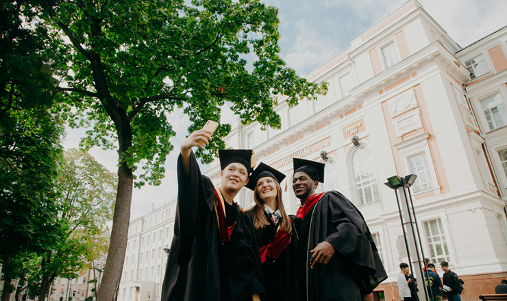 Three graduates smiling as they take a selfie